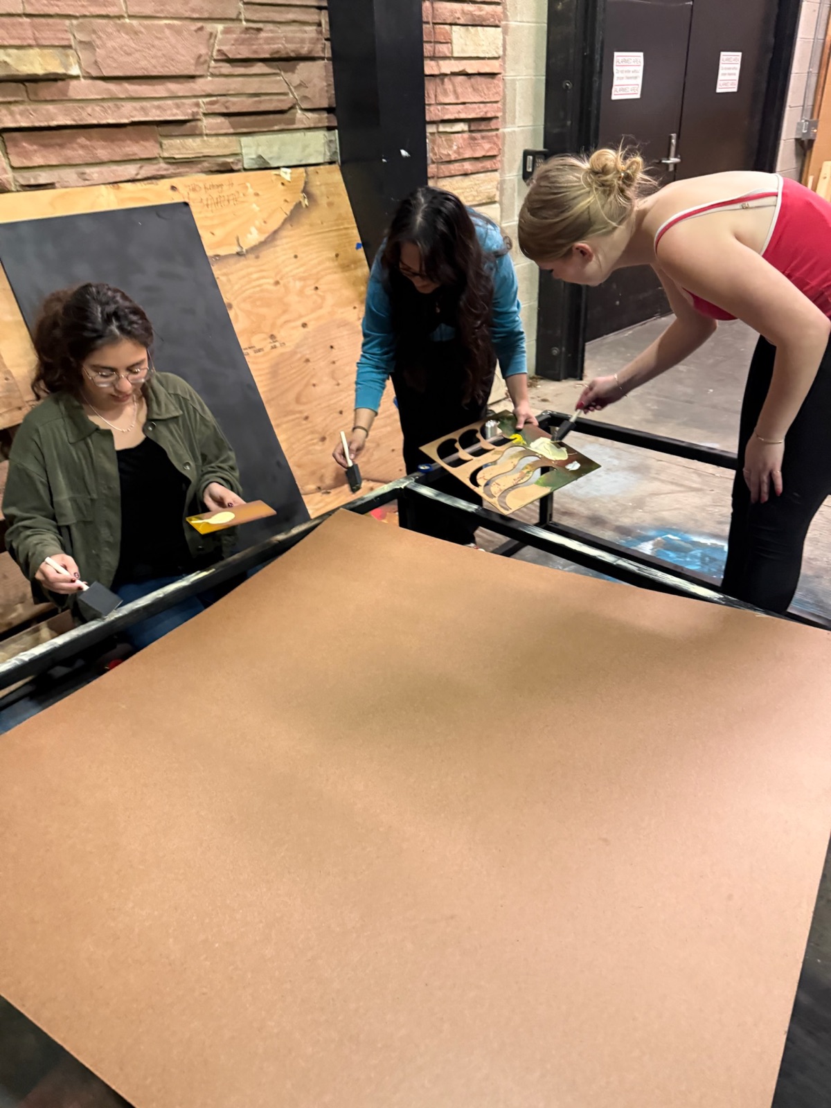 Team painting wooden panels for the exhibit